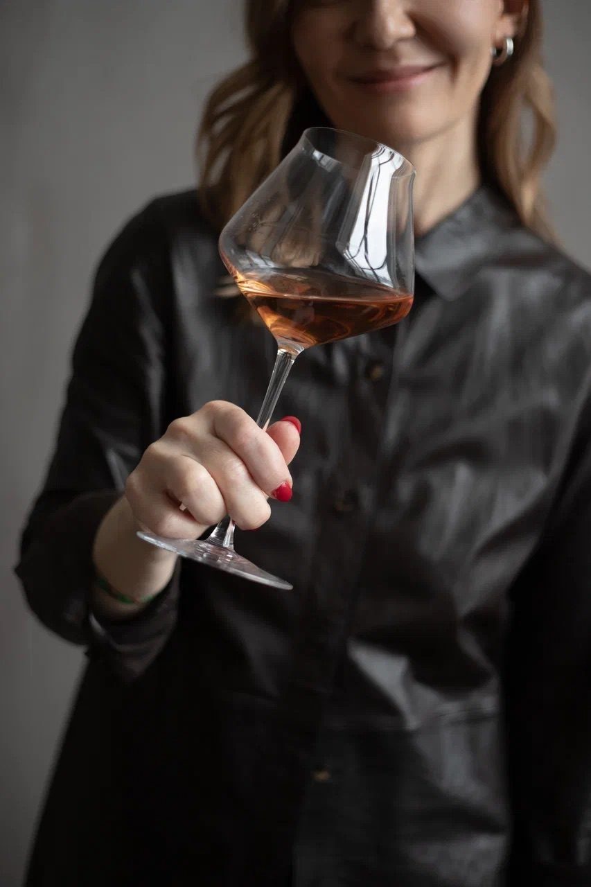 Liubov Leonova tilting a glass of rosé to assess its colour